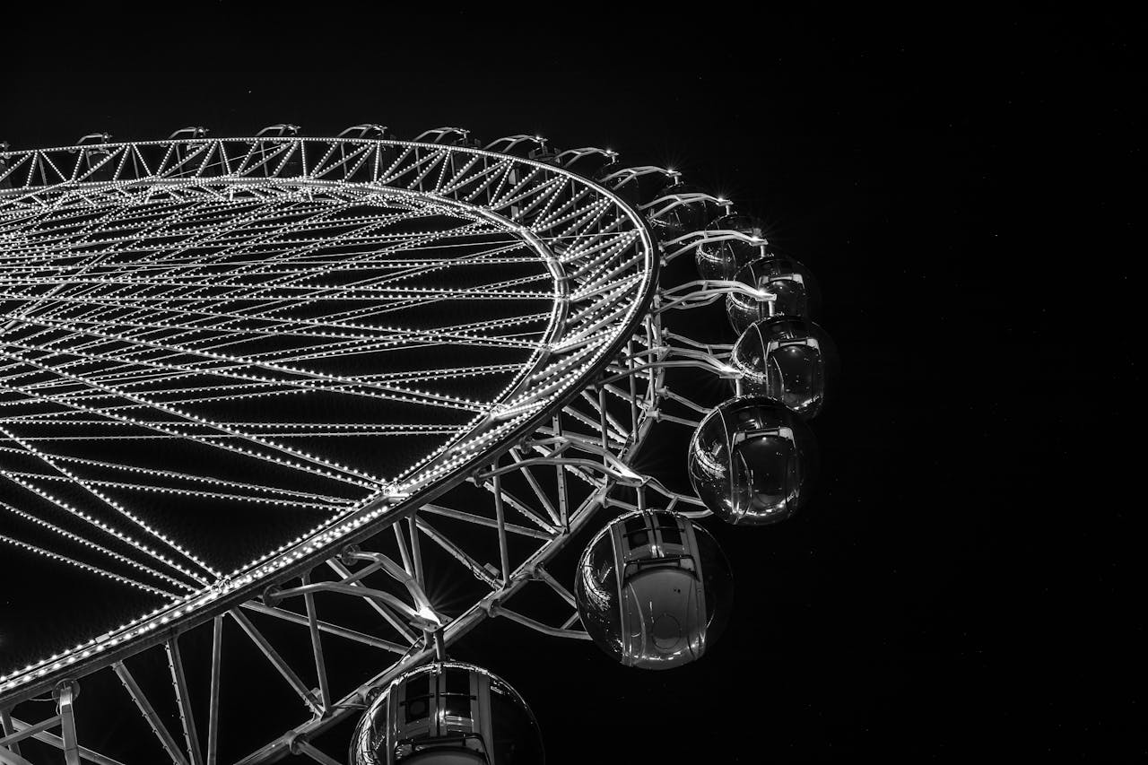 Black and white photo of a glowing Ferris wheel against the night sky.